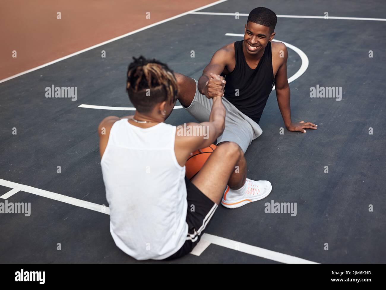 Basketball bros. two sporty young men shaking hands on a basketball