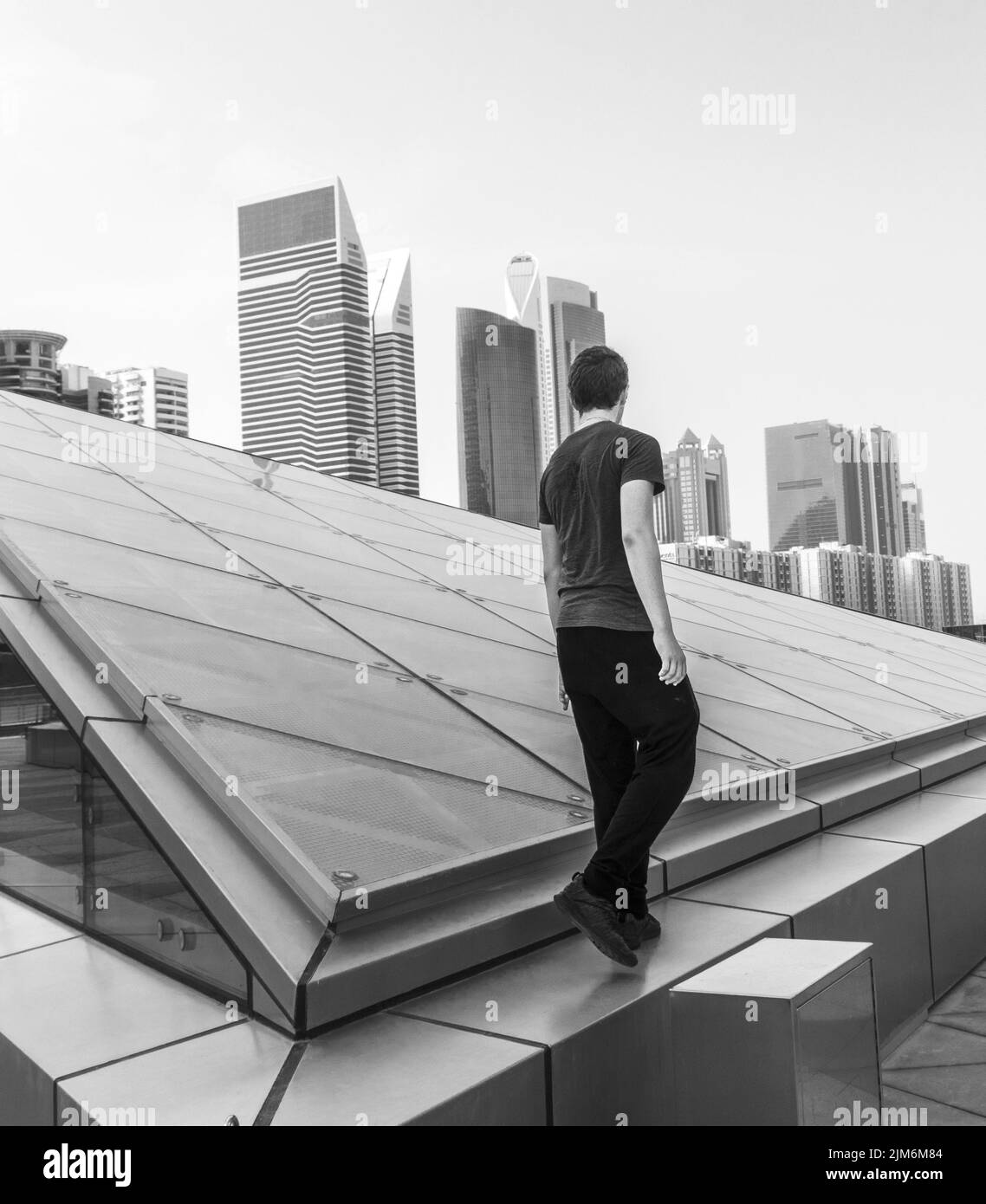 Black and white shot of a young boy with modern city on the background Stock Photo