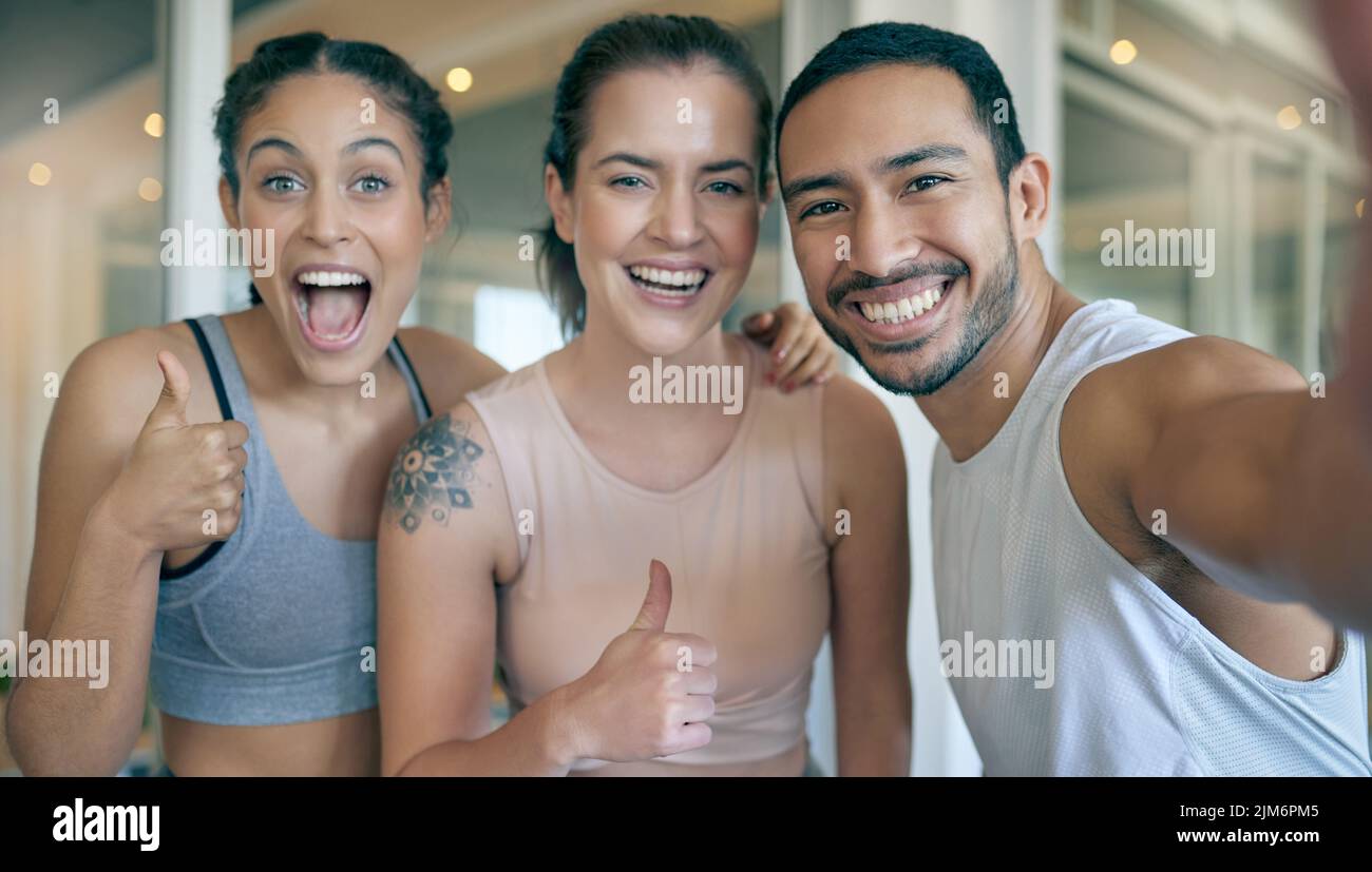 We look forward to seeing you at the gym. three young athletes taking a selfie while standing together in the gym. Stock Photo
