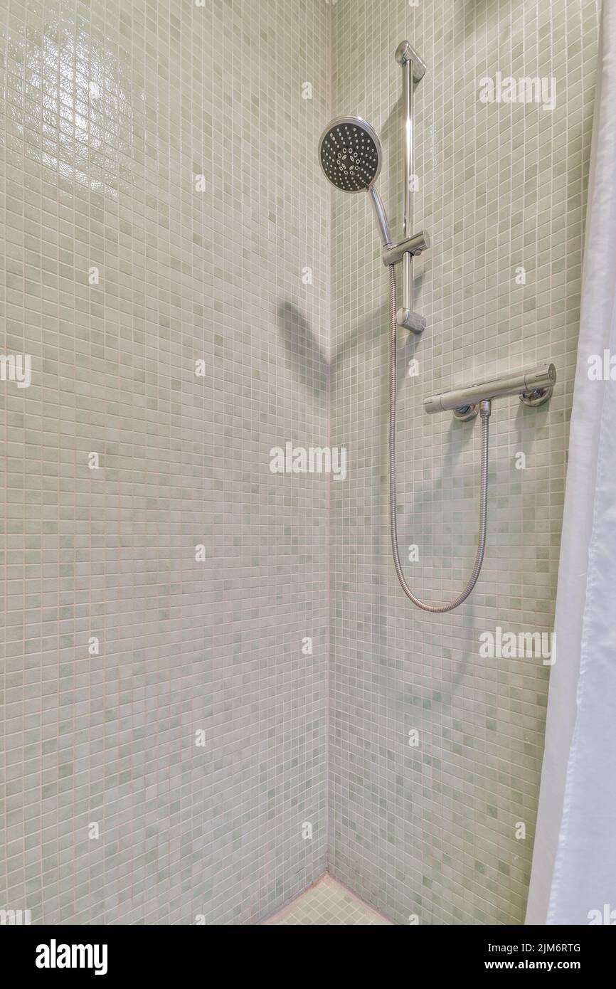 Wall hung toilet and small sink in corner in lavatory room with beige