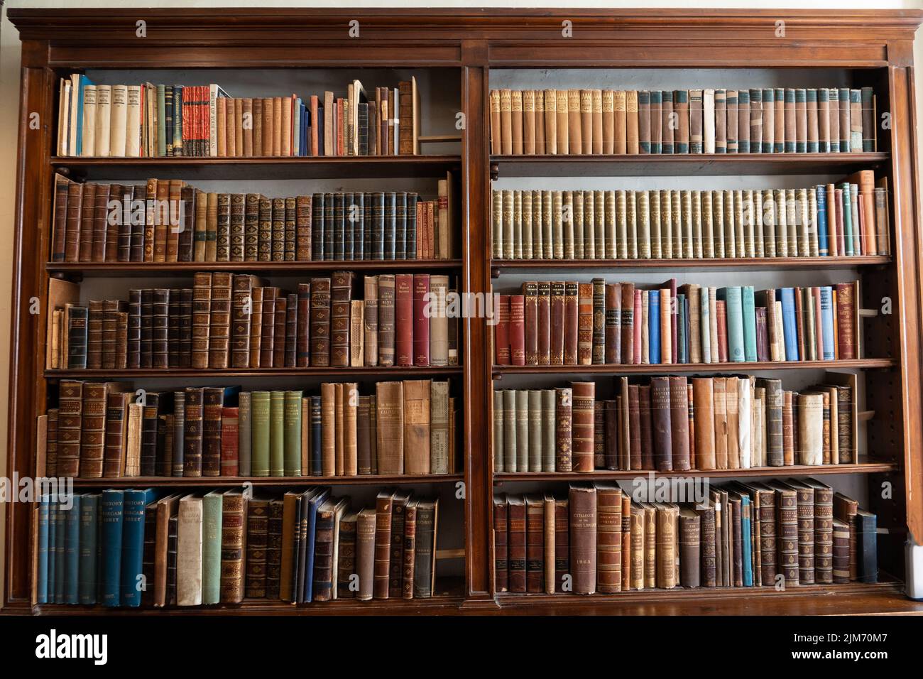 Vertical closeup of the antique books on the bookshelf. Stock