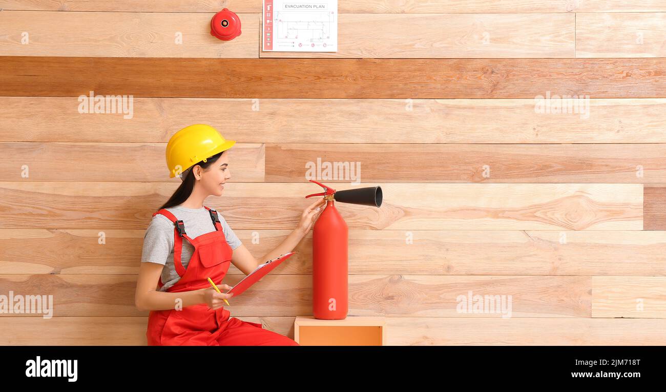 Fire safety specialist inspecting extinguisher in premises Stock Photo