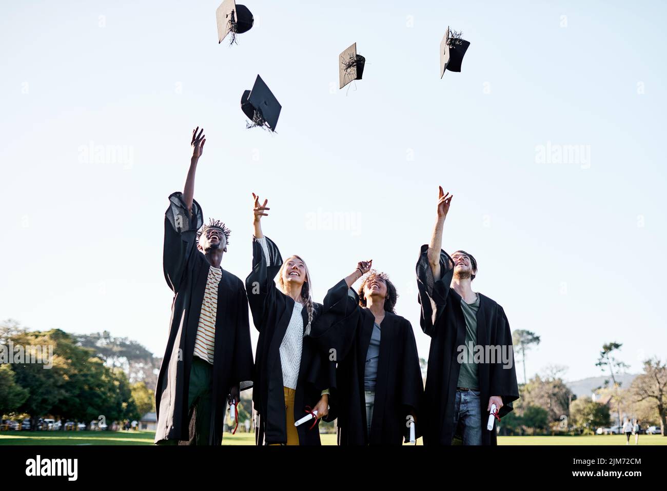 Thrilled about their new milestone. a group of students throwing their