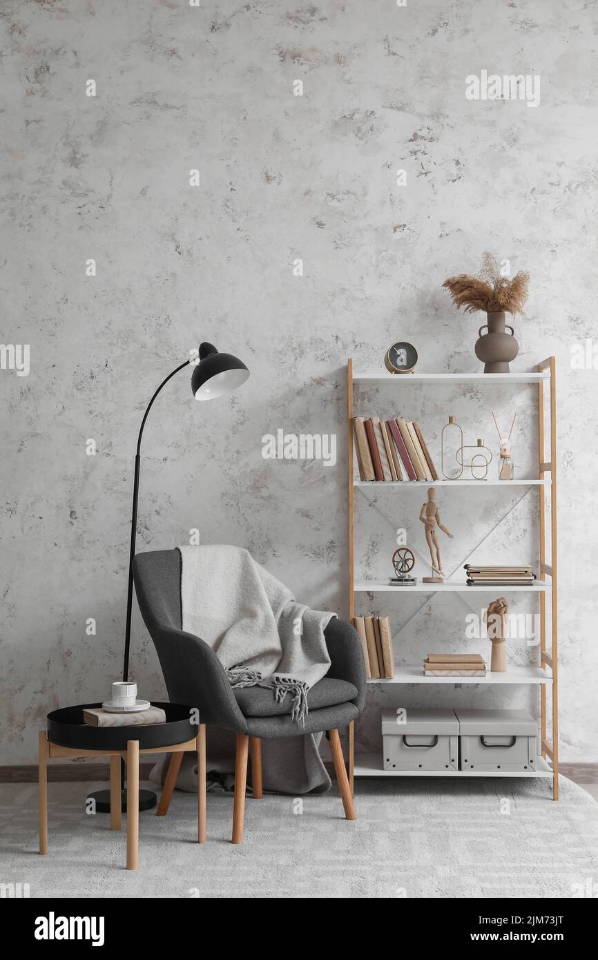 Interior of modern living room with bookcase, armchair and lamp Stock ...