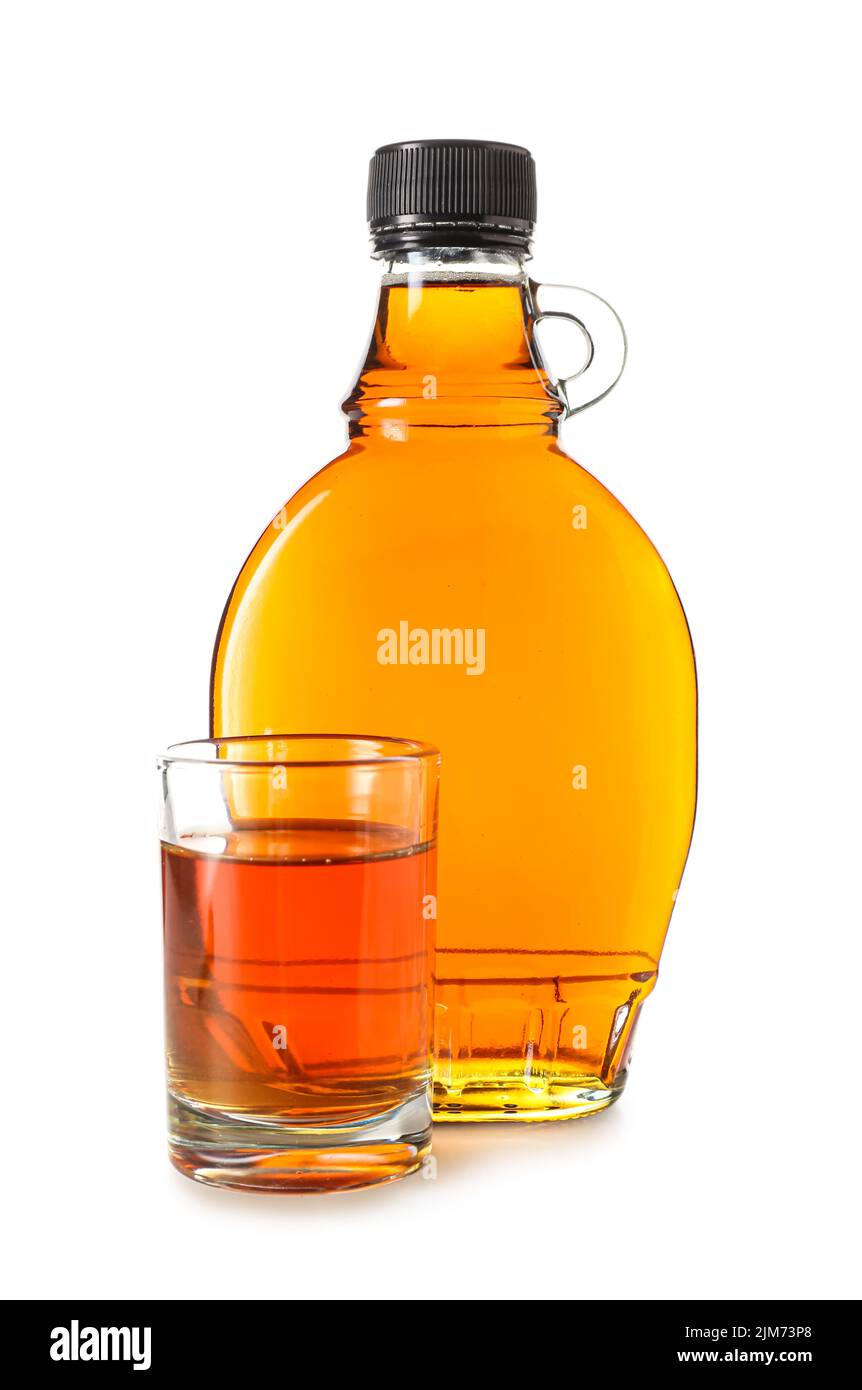 Bottle and glass of maple syrup on white background Stock Photo Alamy