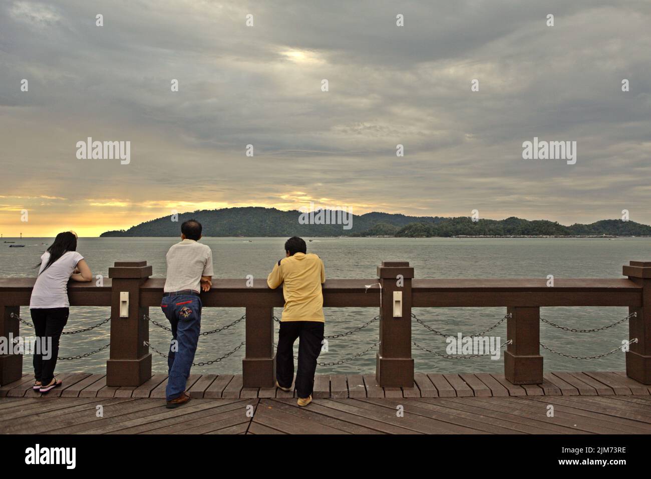 People enjoying afternoon seascape view as they are having a leisure time on a seaside viewing platform in Kota Kinabalu, Sabah, Malaysia. Stock Photo