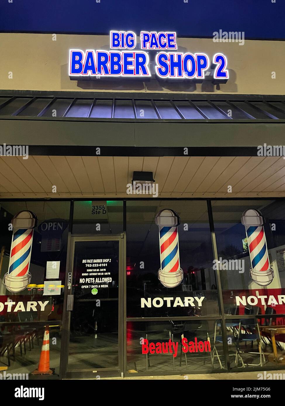 Grovetown, Ga USA - 04 29 22: Big Pace Barber Shop 2 entrance at night Stock Photo