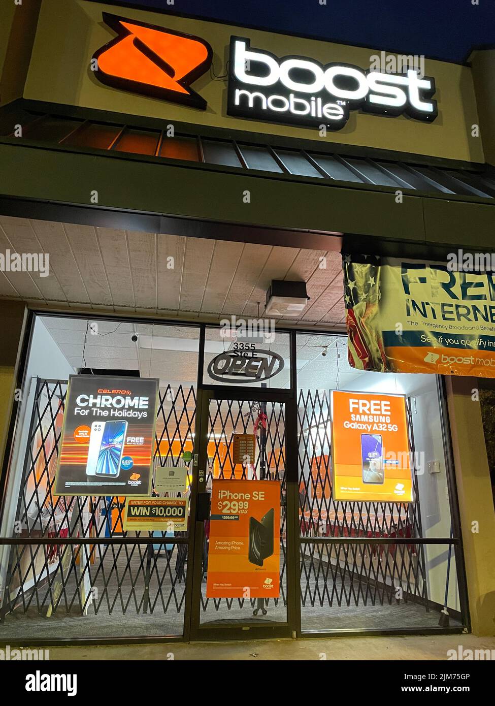 Grovetown, Ga USA - 04 29 22: Boost Mobile retail store front at night illuminated sign Stock Photo