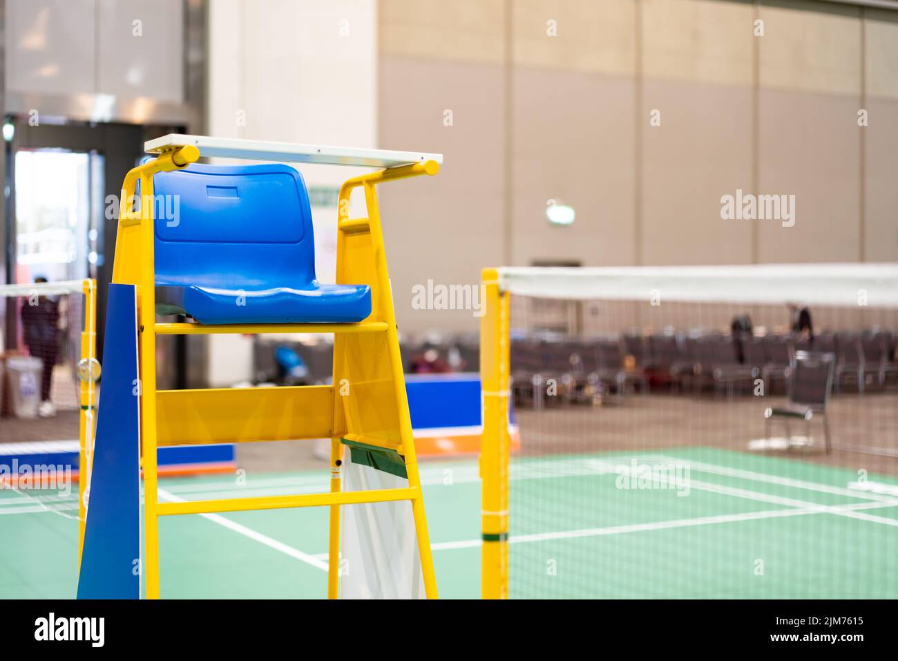 Blue chair of badminton referee with yellow colors near badminton net
