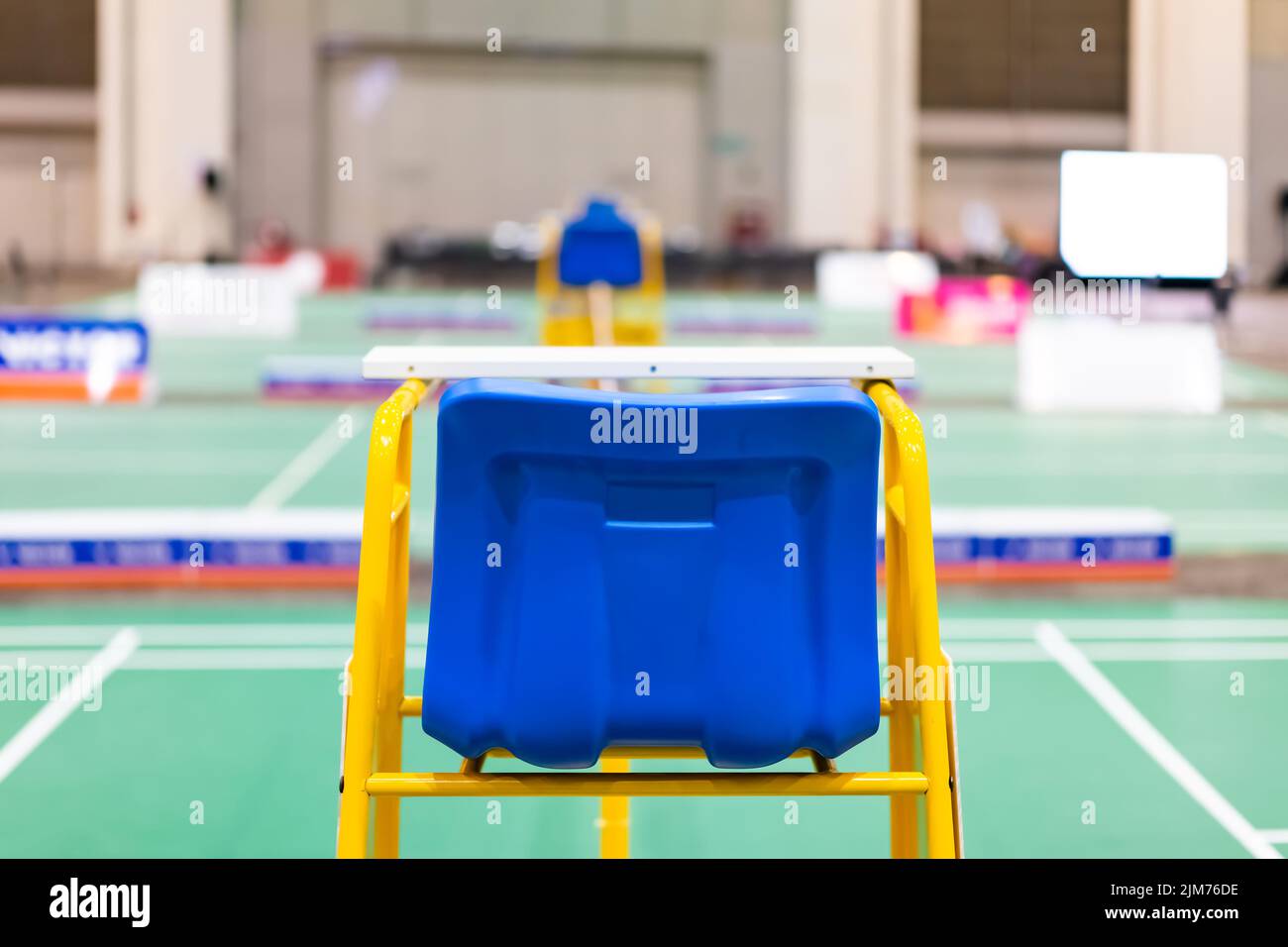 Blue chair of badminton referee with yellow colors near badminton net