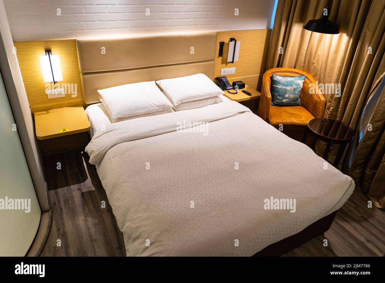 A modern luxury hotel room with a queen bed. Stock Photo