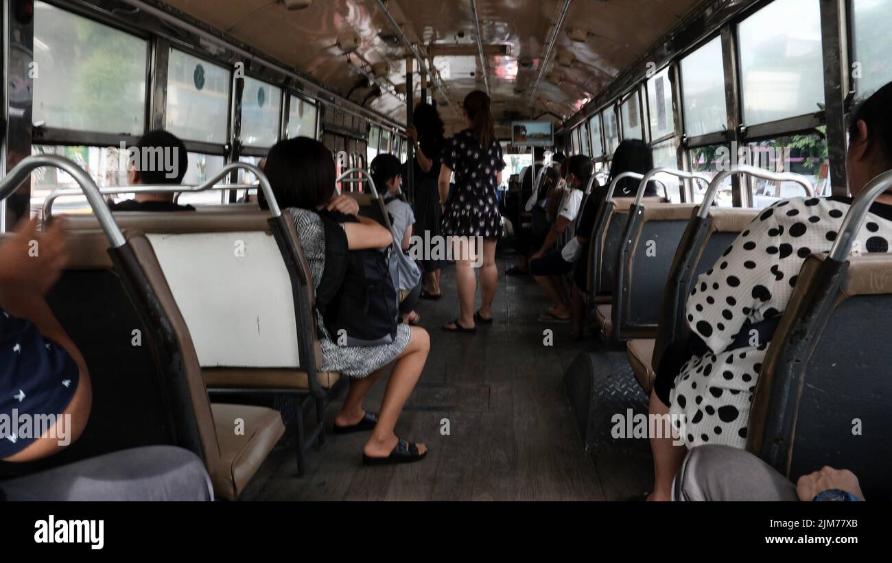 Passengers Riding inside a local Bangkok City Bus Stock Photo