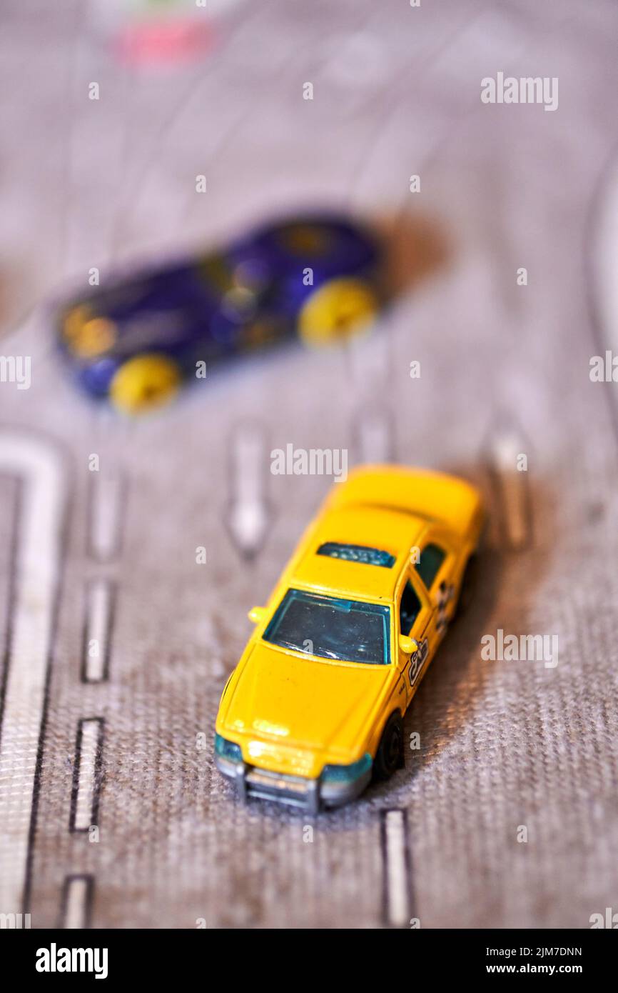 A vertical shot of a Mattel Matchbox toy model taxi car on a play road Stock Photo