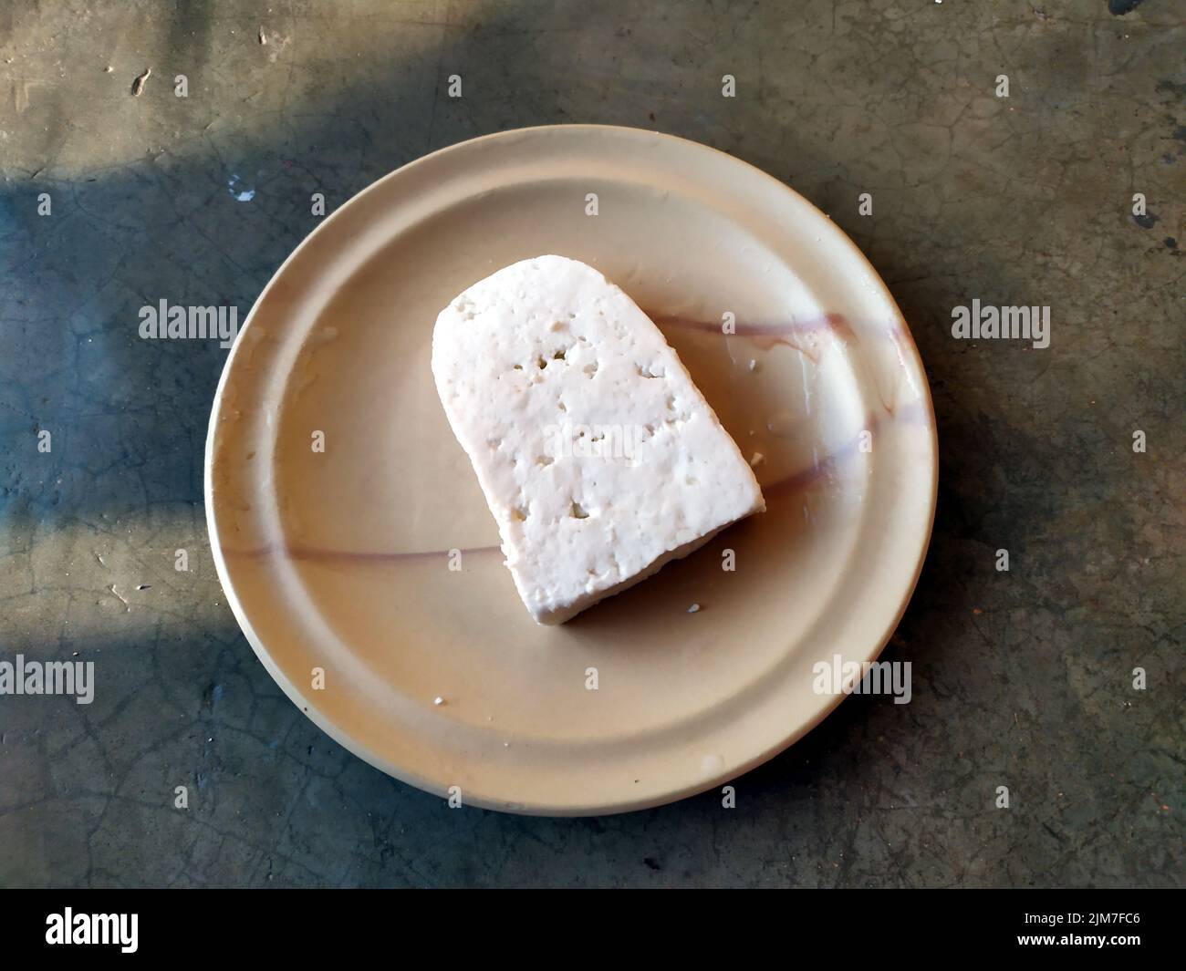 paneer slice put in a plate with stone background Stock Photo