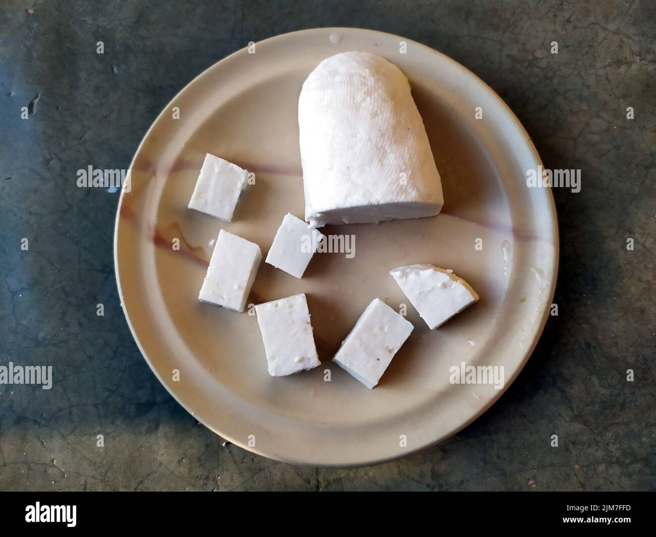 paneer slice put in a plate with stone background Stock Photo