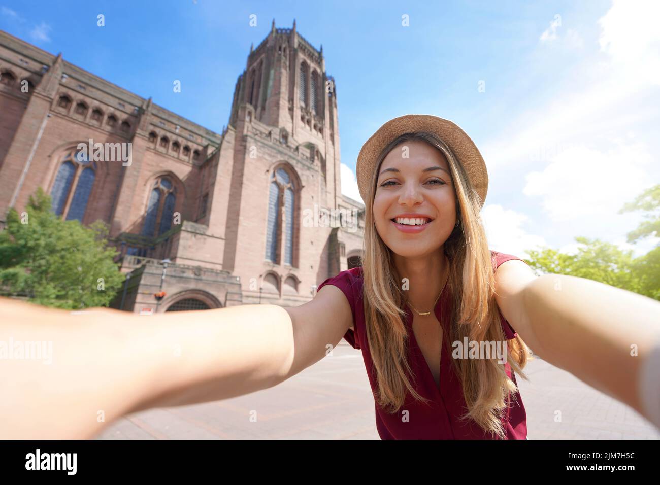 Beautiful young woman taking selfie photo in front of Liverpool