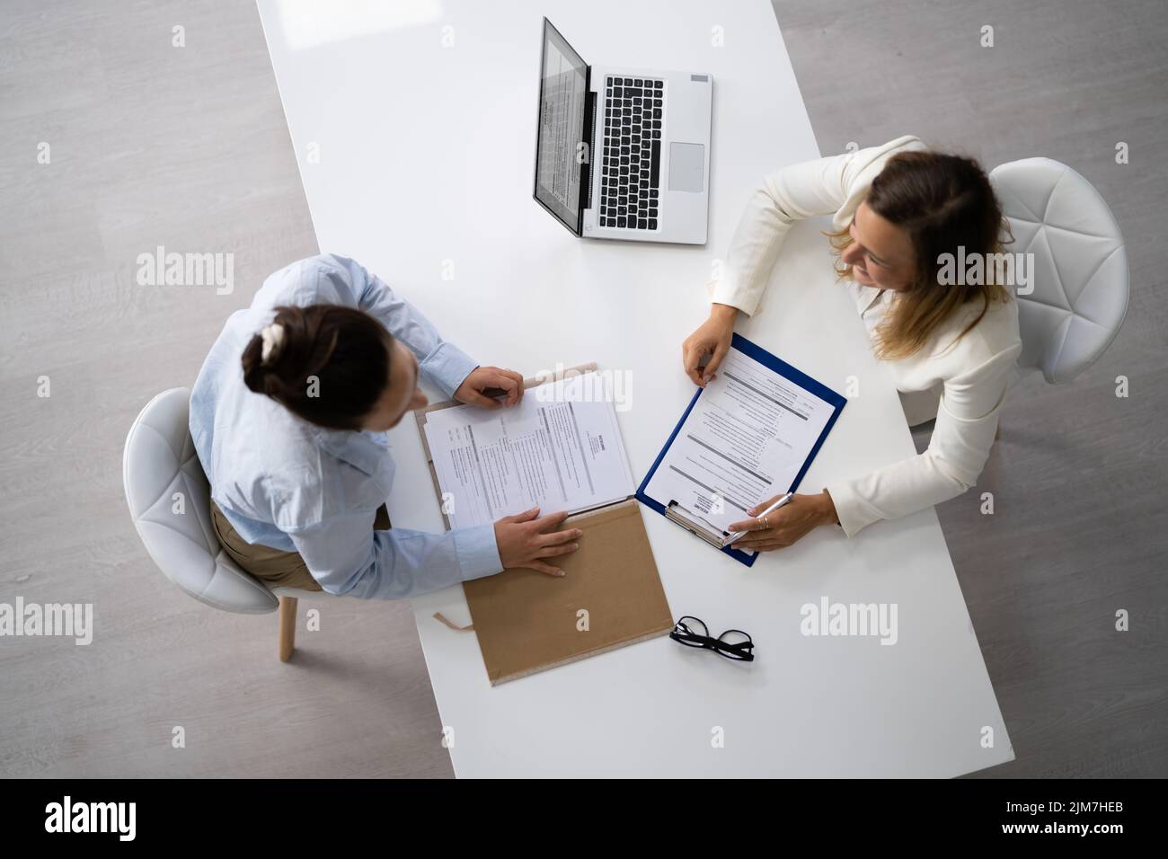 Happy Businesswoman And Businesswoman Discussing In Office Stock Photo