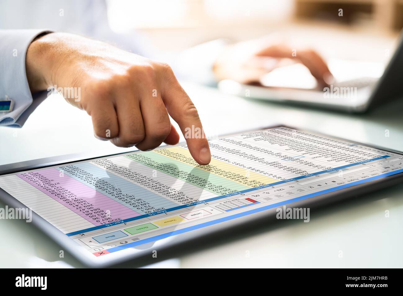 Man Using Spreadsheet Data On Tablet Computer Stock Photo
