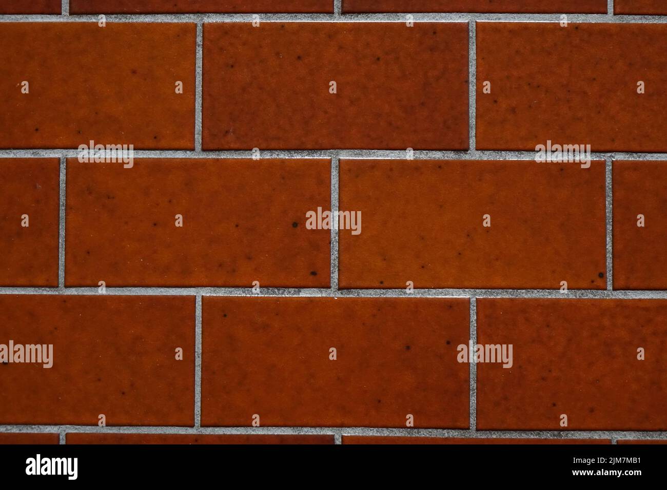 Close up Dark red tile floor, white cement filling gaps, black spots