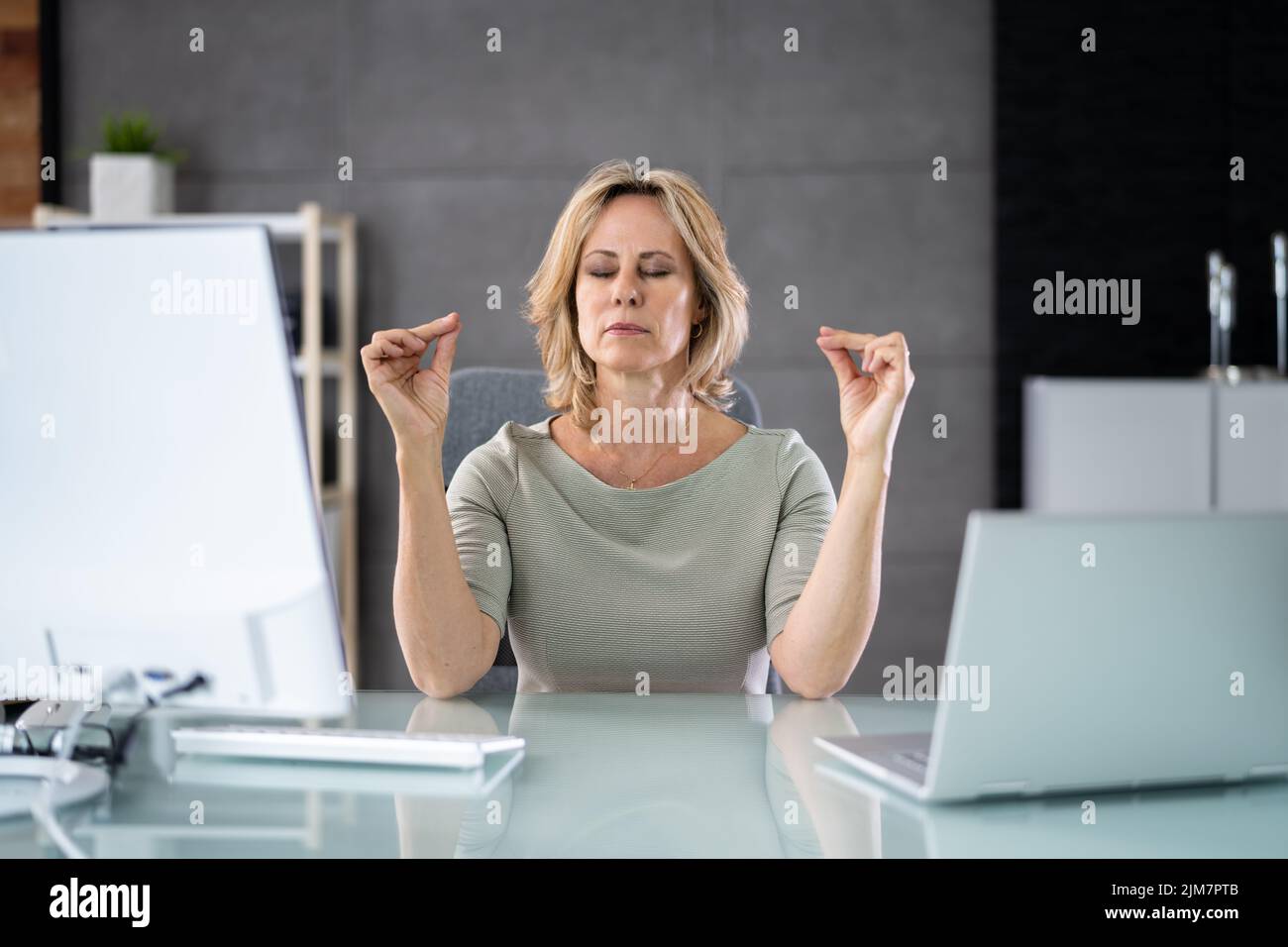 Healthy Yoga Meditation Exercise In Office Chair At Workplace Stock Photo