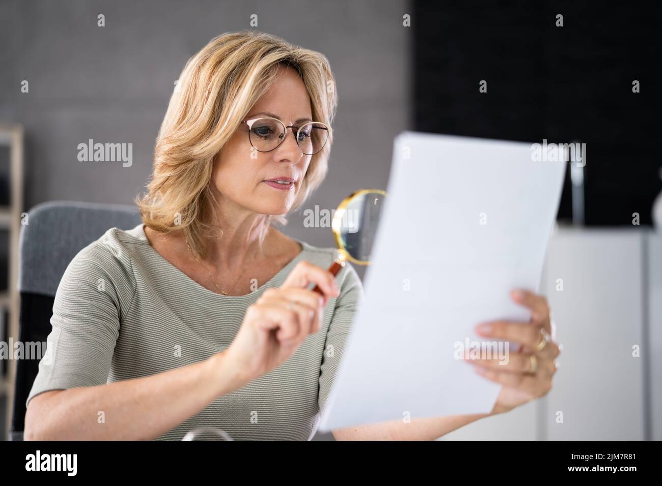 Investigate Fraud And Examine Document Using Magnifying Glass Stock Photo