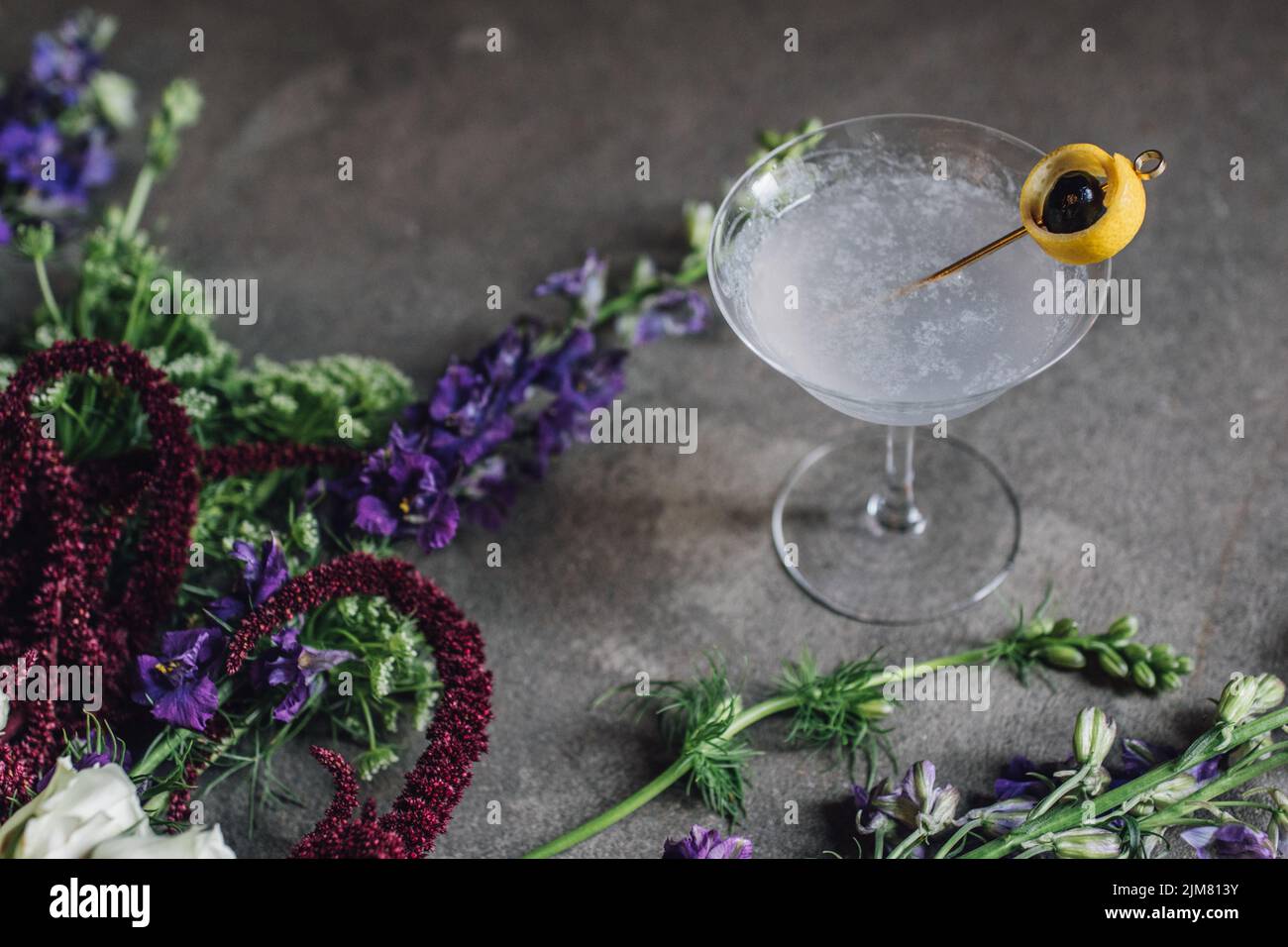 purple gin Aviation cocktail with lemon and cherry garnish on concrete