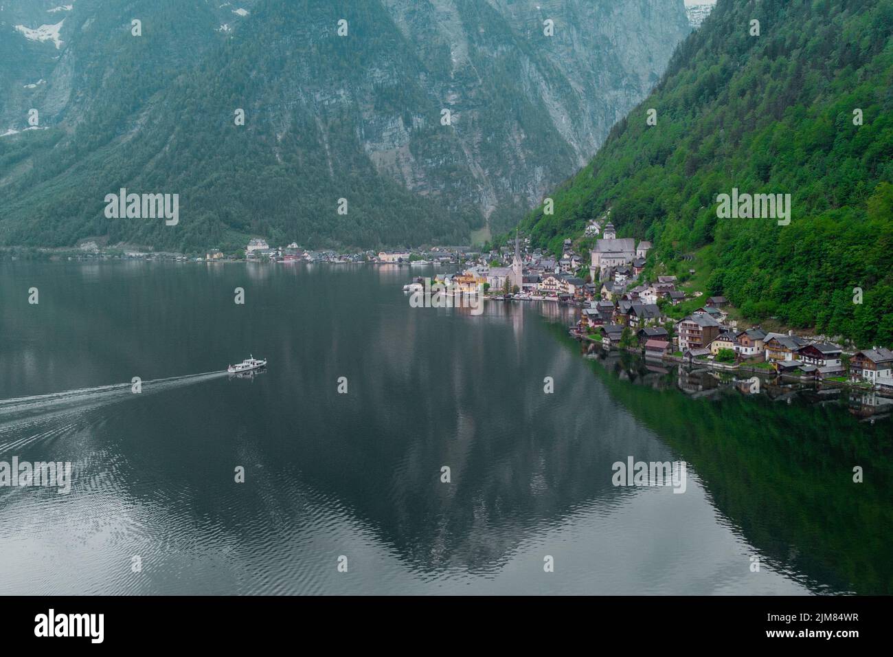 Beautiful drone view of Hallstatt, Austria, picturesque village on the edge of a lake. Classical view with one of the ships just arriving. Stock Photo