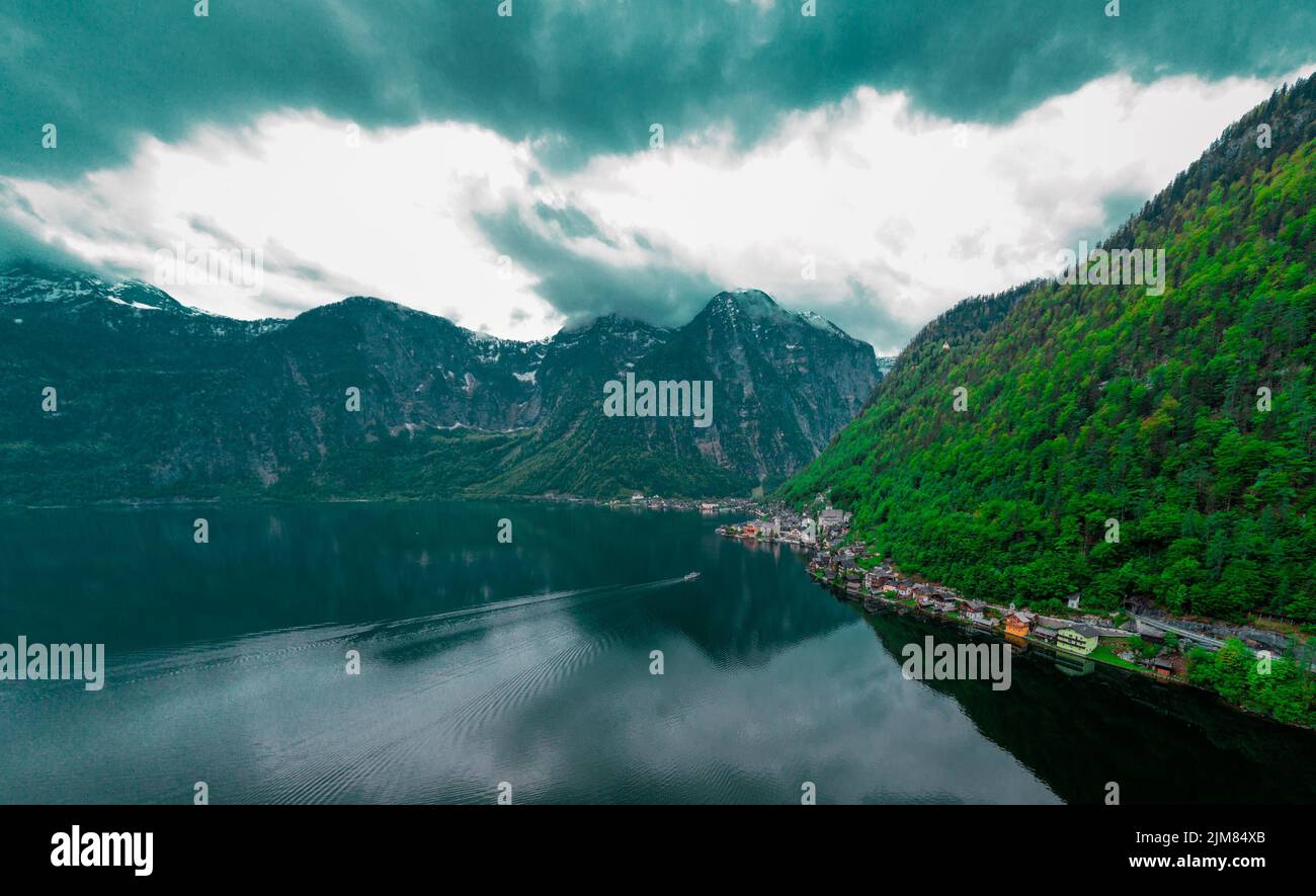 Beautiful drone view of Hallstatt, Austria, picturesque village on the edge of a lake. Classical view with one of the ships just arriving. Stock Photo