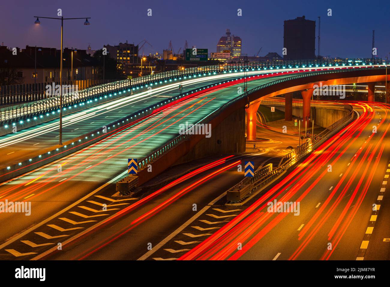 Illuminated city overpass in the evening with light trails Stock Photo