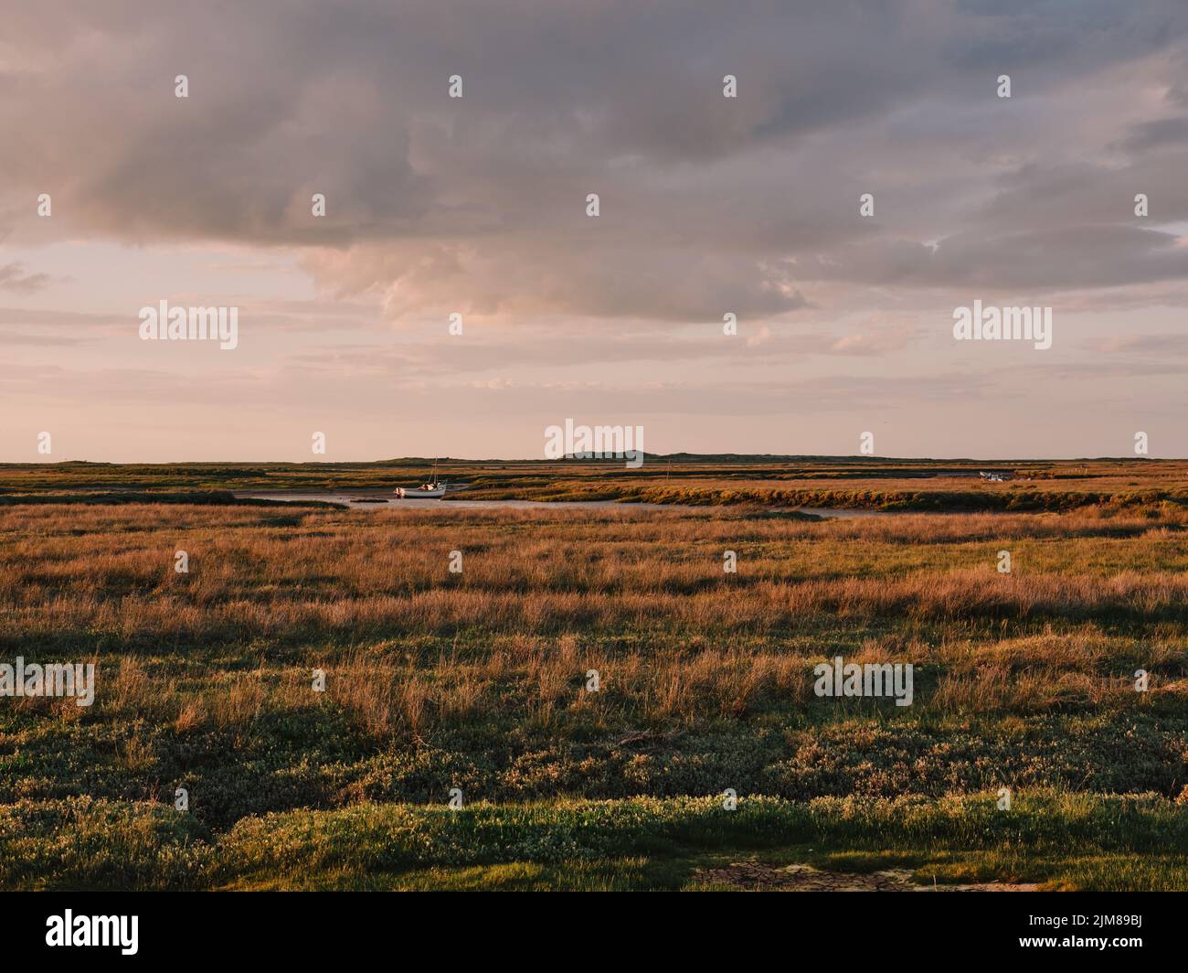 Burnham Deepdale Brancaster North Norfolk marsh coastline and sky landscape at sunset - England UK - marshes marshland low tide Stock Photo