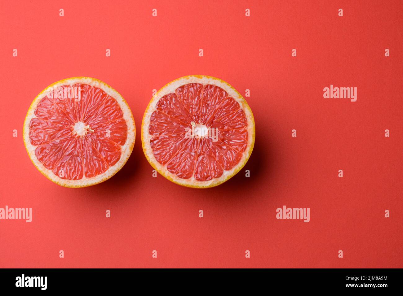 Closeup view of grapefruit on a red background Stock Photo