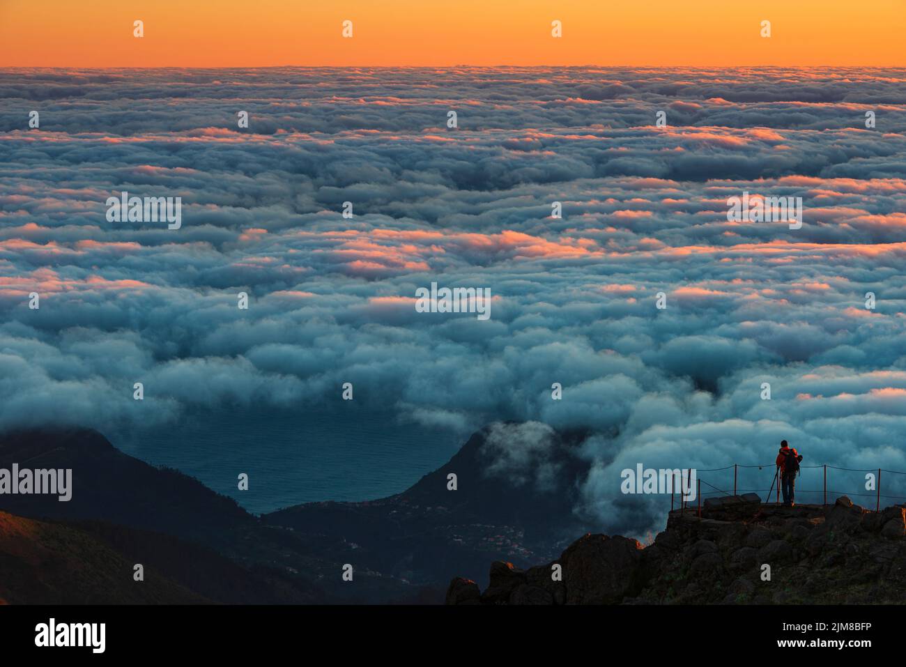 Silhouette of photographer high above clouds Stock Photo