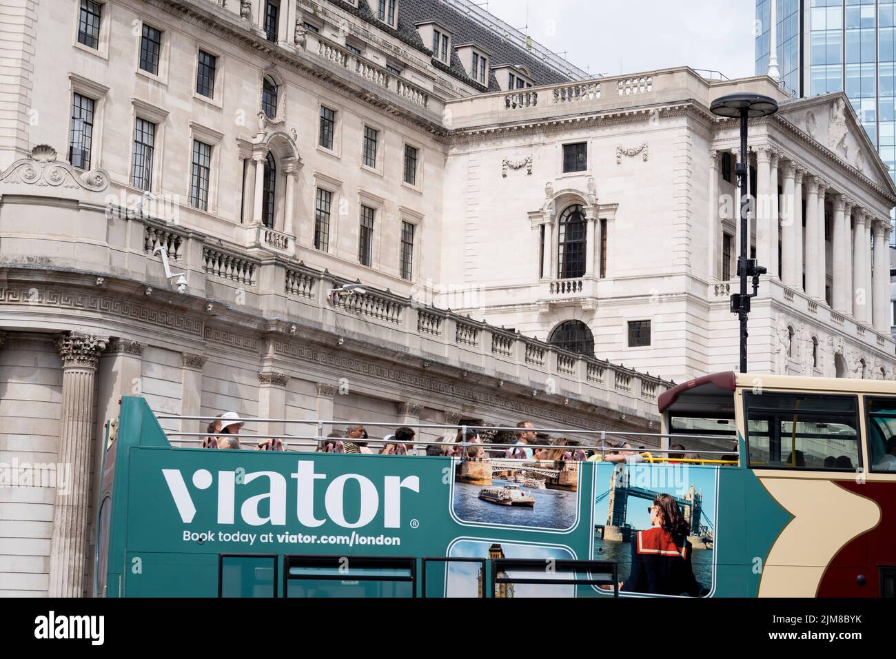 On the day that the Bank of England announced a rise, from 1.25% to 1.75% in the interest rate, the highest increase in 27 years, a tour bus and tourists drives past an exterior of the Bank of England, on 4th August 2022, in the City of London, England. This increase is widely seen as a slide towards inflation with a shrinking of the UK economy - the start of its fall into recession in the third financial quarter of 2022. Stock Photo