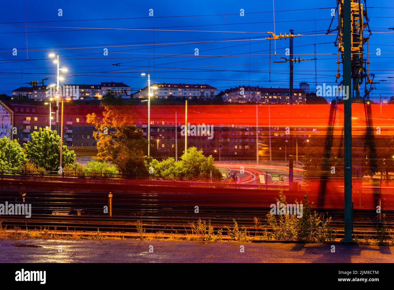 Train passing by at city in evening Stock Photo