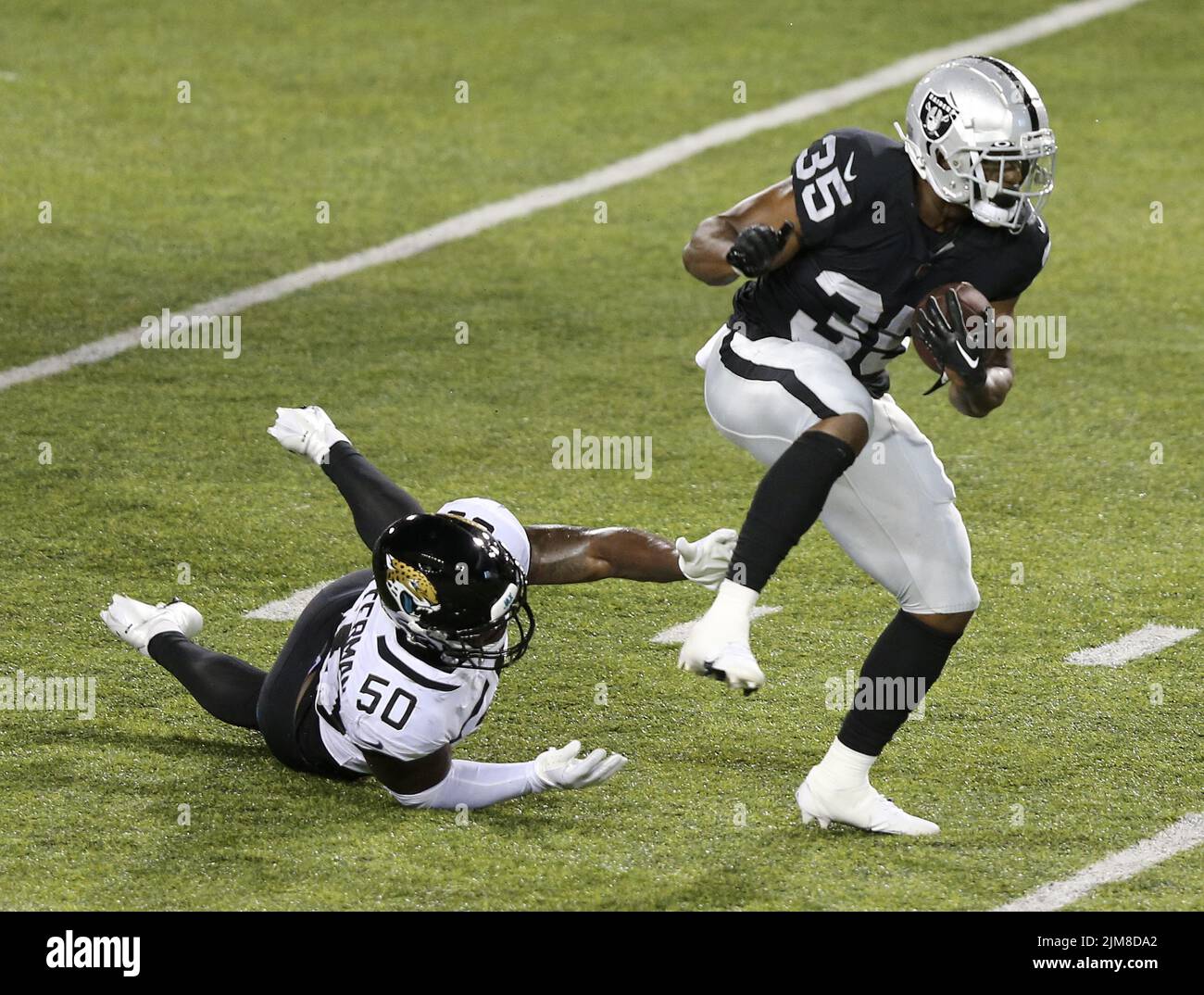 Canton, United States. 04th Aug, 2022. Las Vegas Raiders Zsmir White (35) runs out of the grasp of Jacksonville Jaguars Shaquille Quarterman (50) after making a catch in the first half of the Pro Football Hall of Game in Canton, Ohio, on Thursday, August 4, 2022. Photo by Aaron Josefczyk/UPI Credit: UPI/Alamy Live News Stock Photo