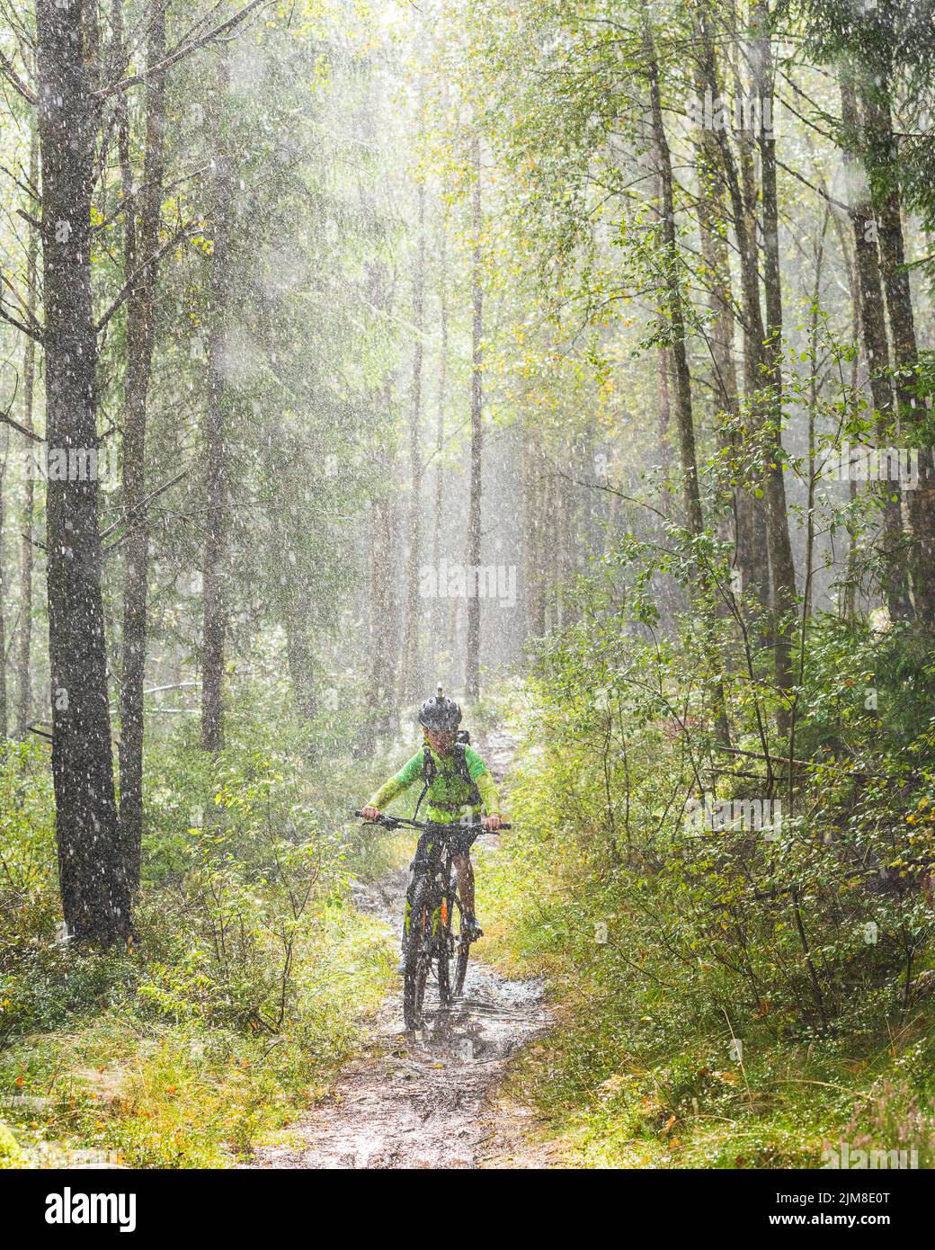 Boy cycle mountainbike in rain Stock Photo