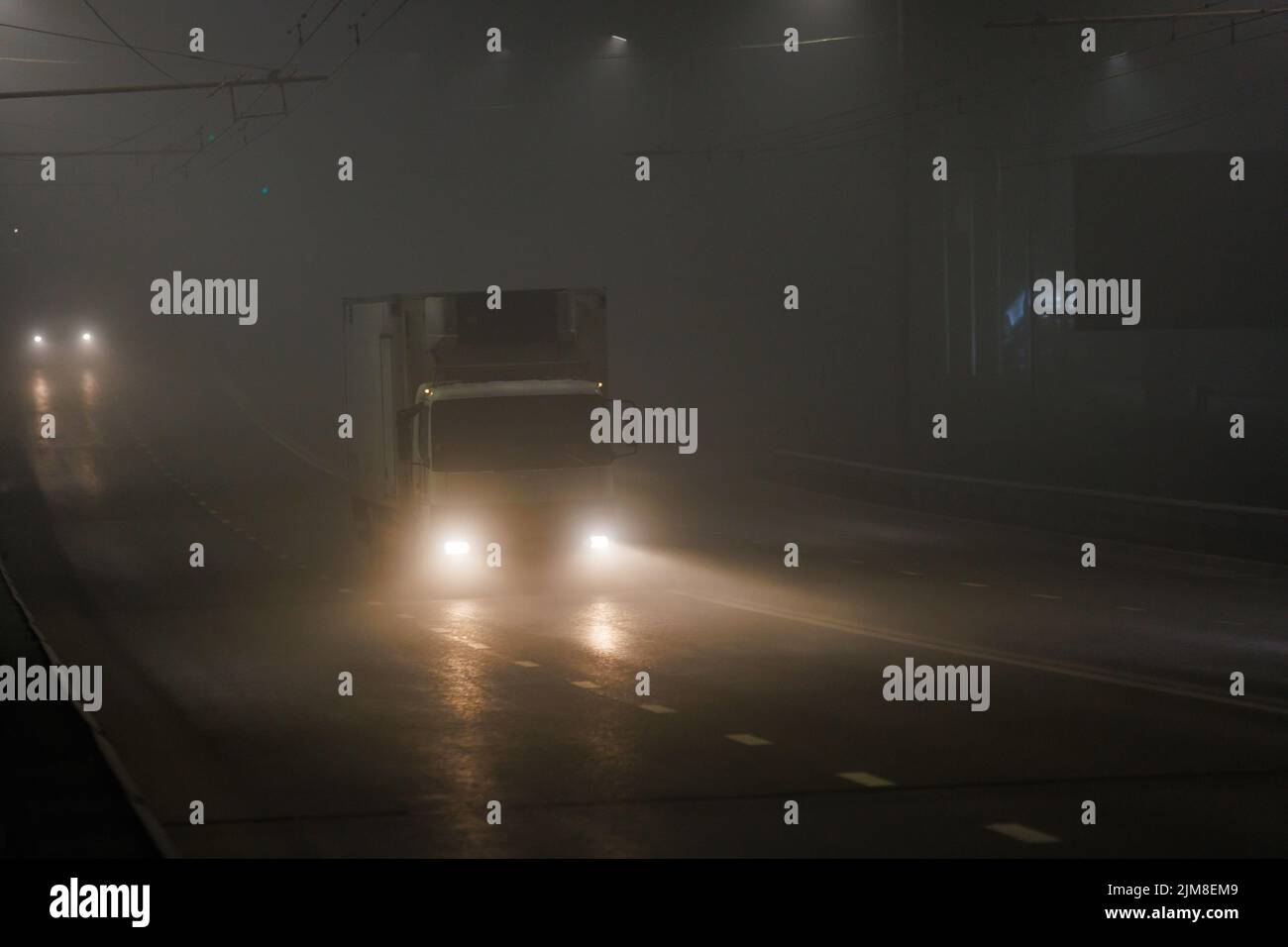 small hoodless dry van truck moving on night foggy road Stock Photo