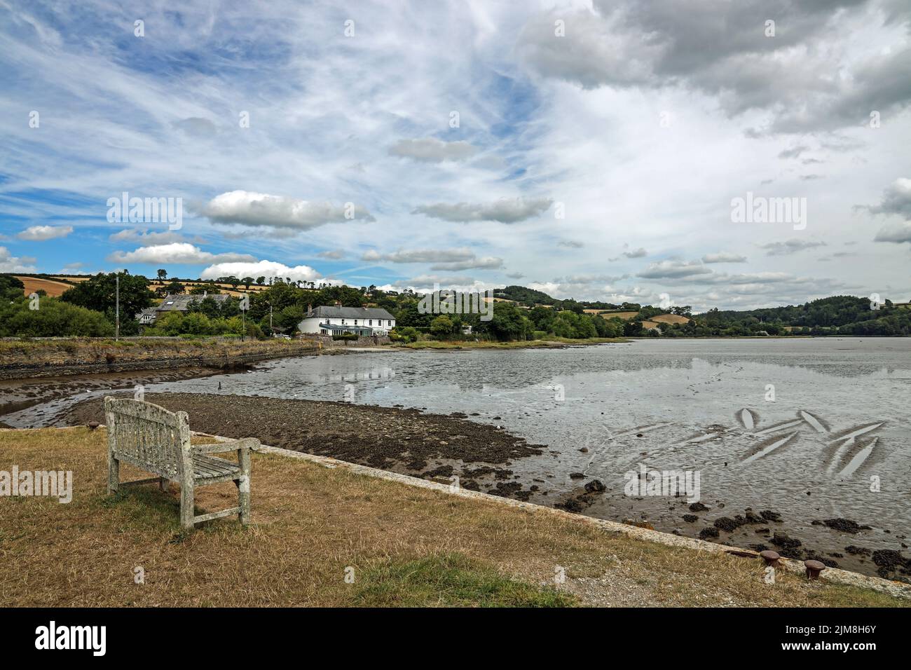 Cottages on the banks of the River Tavy seen from the quayside at Bere Ferrers. The tide is low with patterns in the river bed. Stock Photo