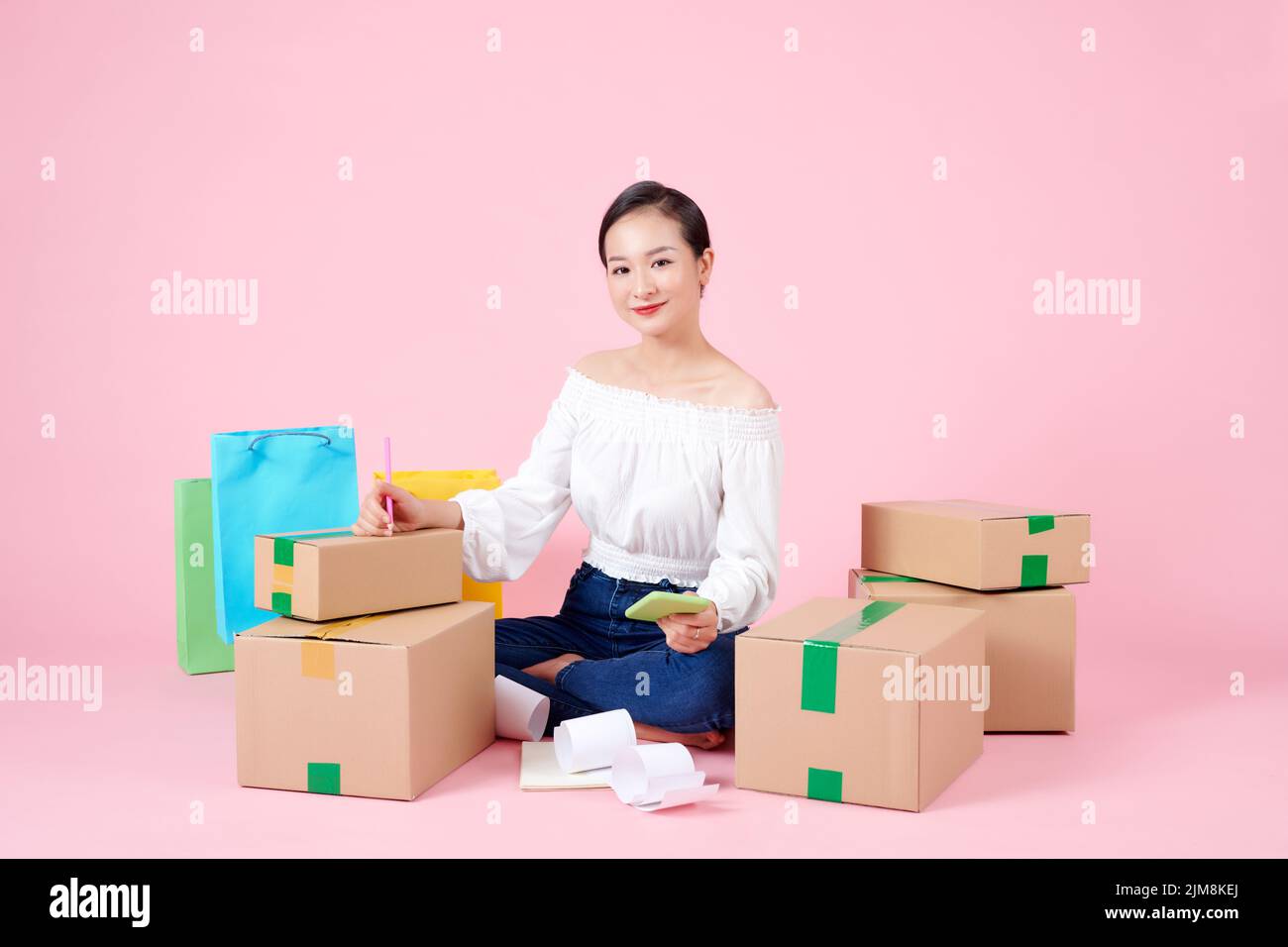 Happy young asian entrepreneurs are arranging boxes for delivering products to customers. Stock Photo