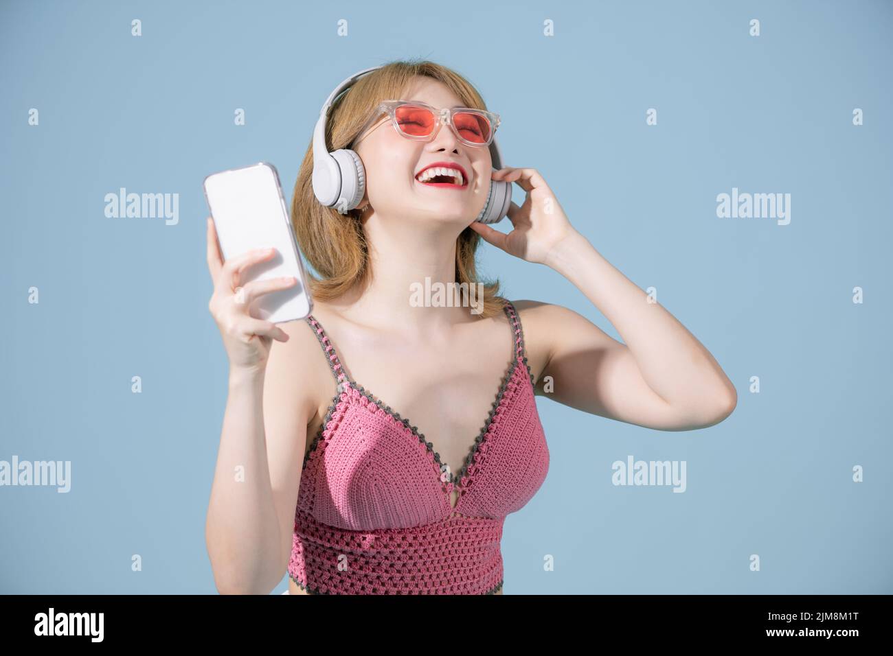 Full length body size view of a pretty cheerful girl listening song having fun dancing chill isolated on blue pastel background Stock Photo