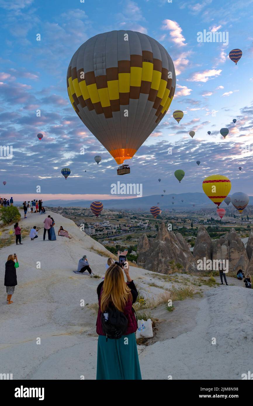 GOREME/TURKEY - June 30, 2022: hot air balloon flies near the tourists . Stock Photo