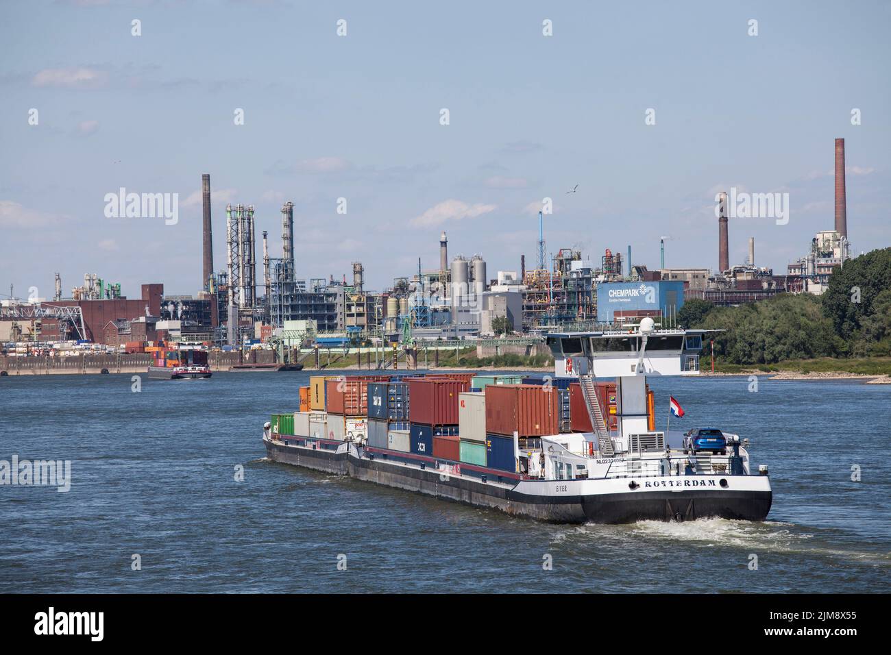 container vessel on the Rhine, view to the Chempark, former known as the Bayer factory, Leverkusen, North Rhine-Westphalia, Germany.  Containerschiff Stock Photo