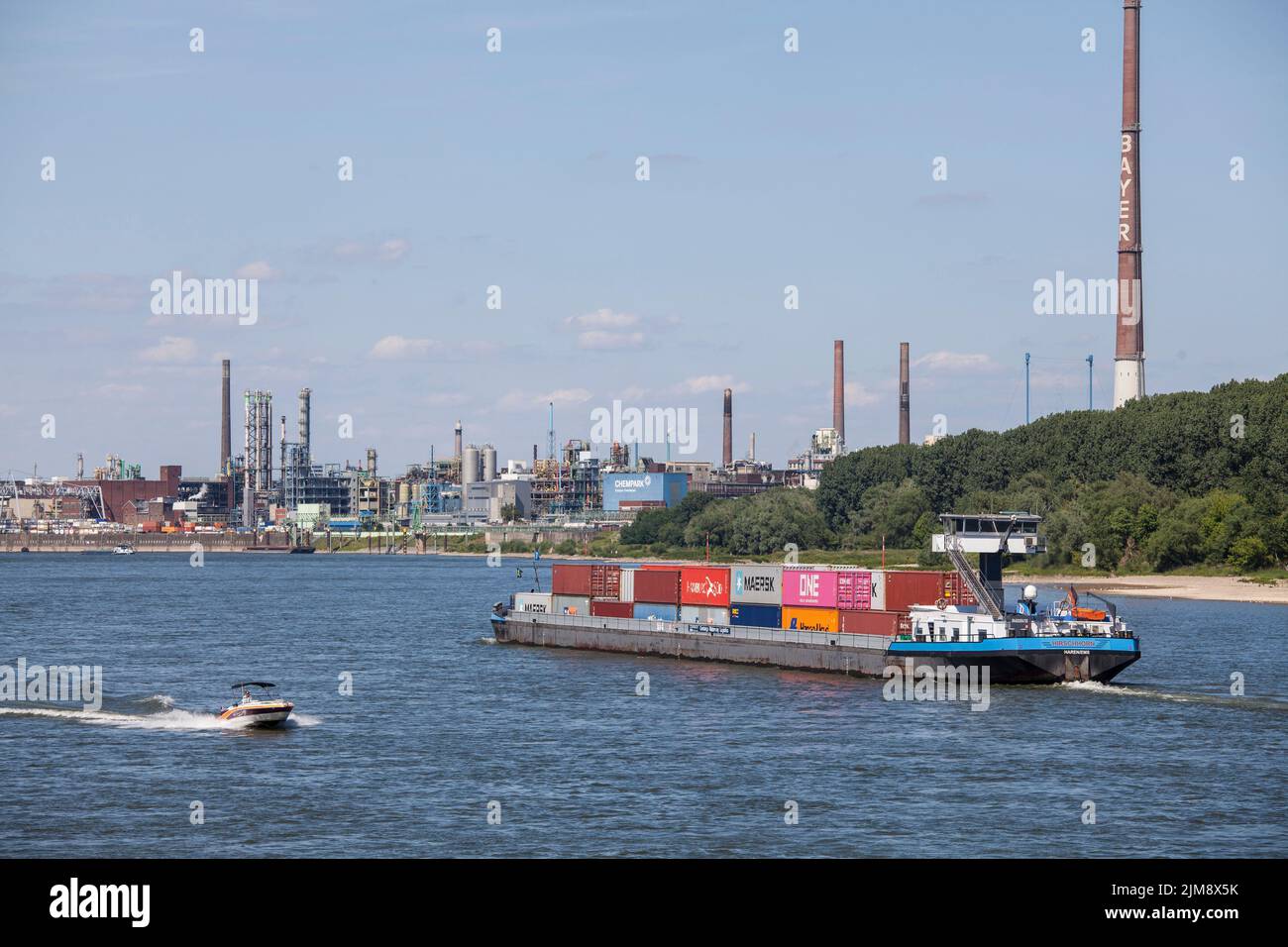 container vessel on the Rhine, view to the Chempark, former known as the Bayer factory, Leverkusen, North Rhine-Westphalia, Germany.  Containerschiff Stock Photo