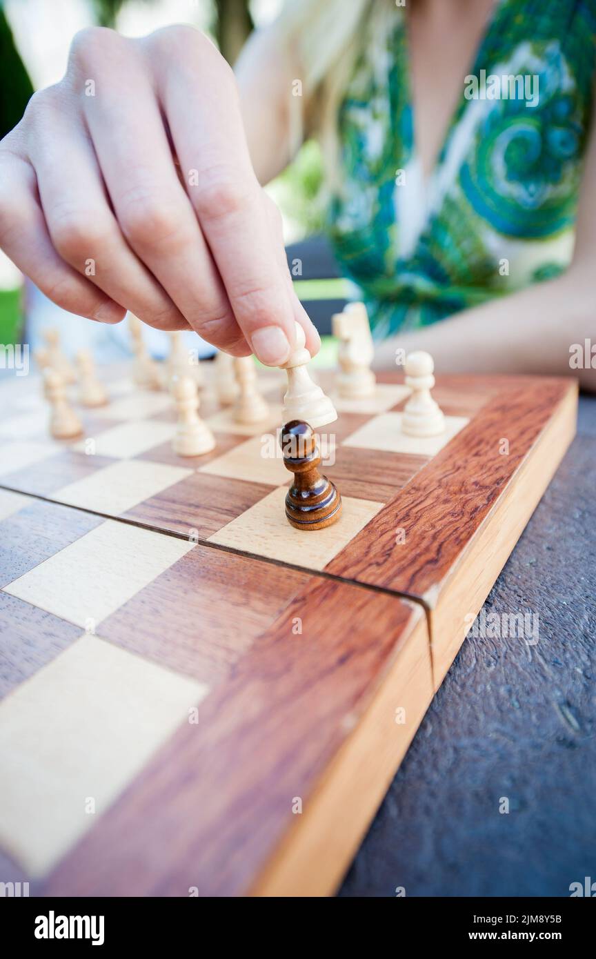 Woman moves piece in chess Stock Photo