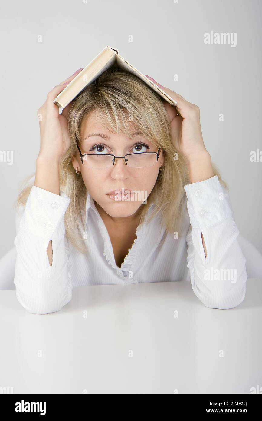 The young woman hides under the book Stock Photo - Alamy