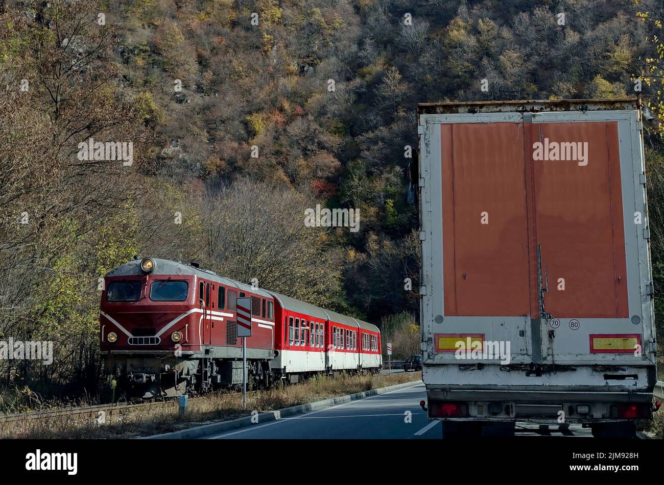 Route of the narrow gauge railway and train with  red locomotive and  wagon arrives from Septemvri station to Dobrinishte crossing the Rhodope Mountan Stock Photo