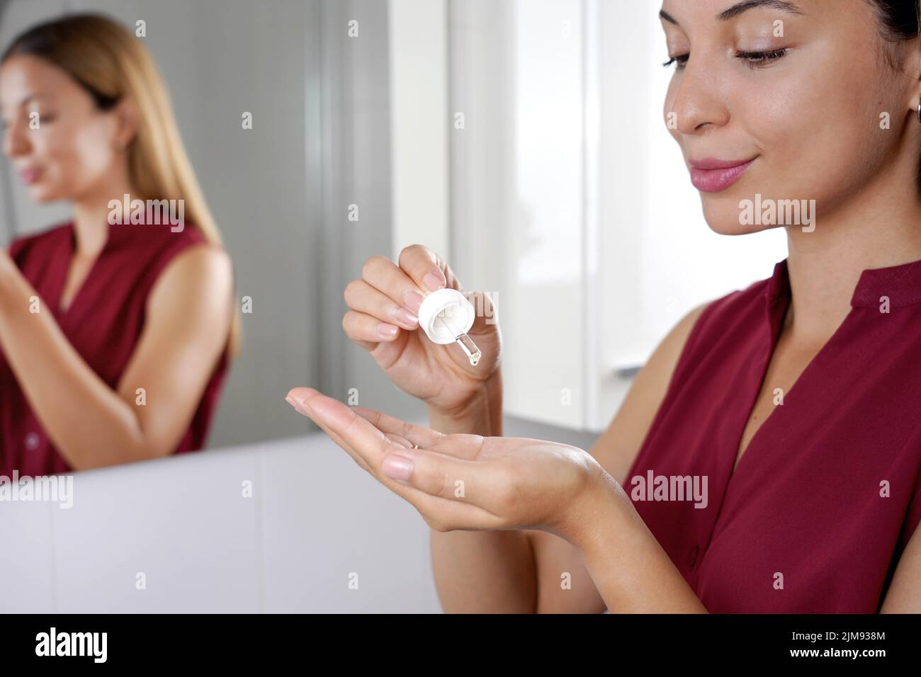 Skincare Routine. Beautiful woman holding a pipette in her hand with serum moisturizing anti aging antioxidant. Stock Photo