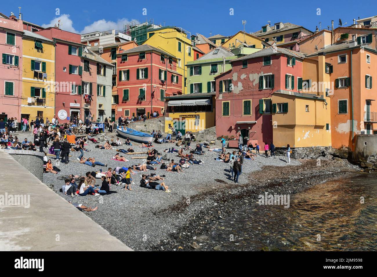 View of the small beach of the old fishing village crowded with tourists on Easter Monday, Boccadasse, Genoa, Liguria, Italy Stock Photo