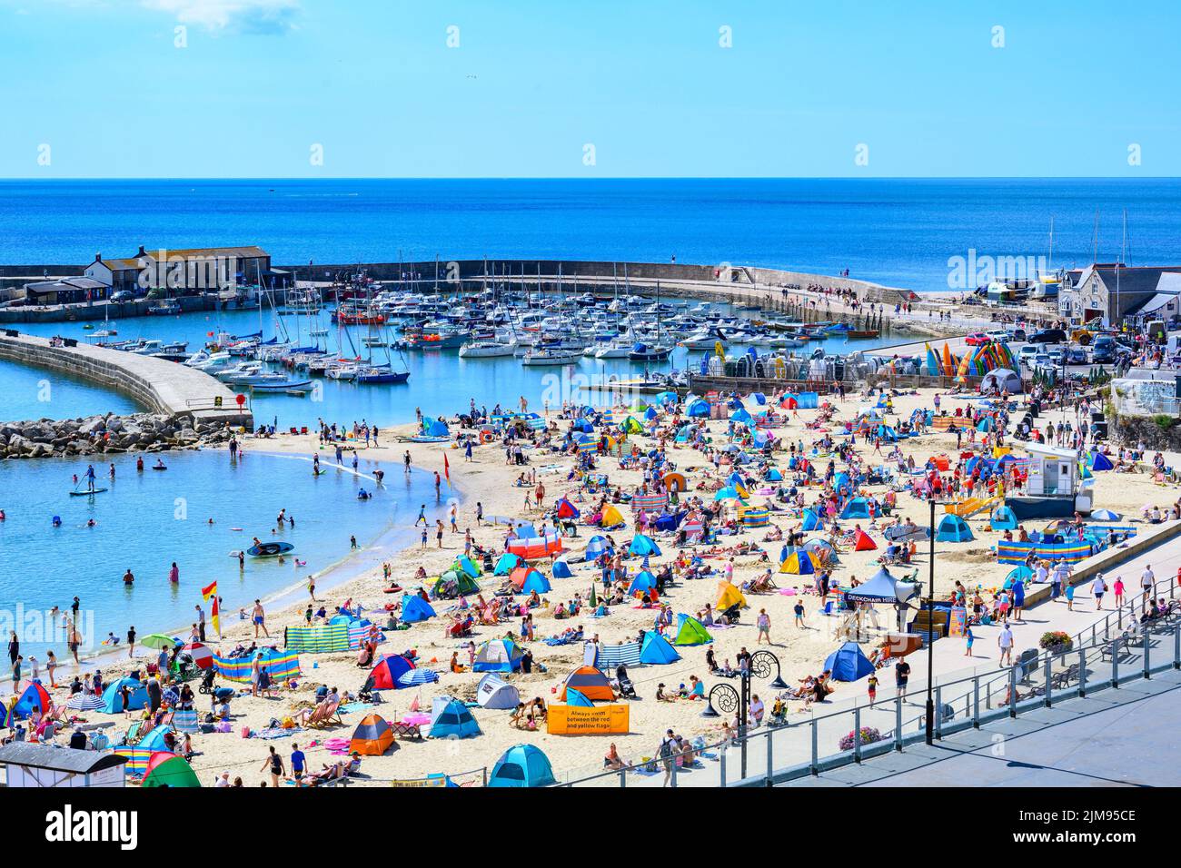 Lyme Regis, Dorset, UK. 5th Aug, 2022. UK Weather: Crowds of holidaymakers and sunbathers flock to the beach to bask in scorching hot sunshine at the seaside resort of Lyme Regis. Credit: Celia McMahon/Alamy Live News Stock Photo