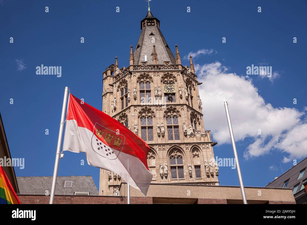 the flag of Cologne in front of the tower of the historical town hall in the old part of the town, Cologne, Germany. die Koelner Flagge vor dem Turm d Stock Photo